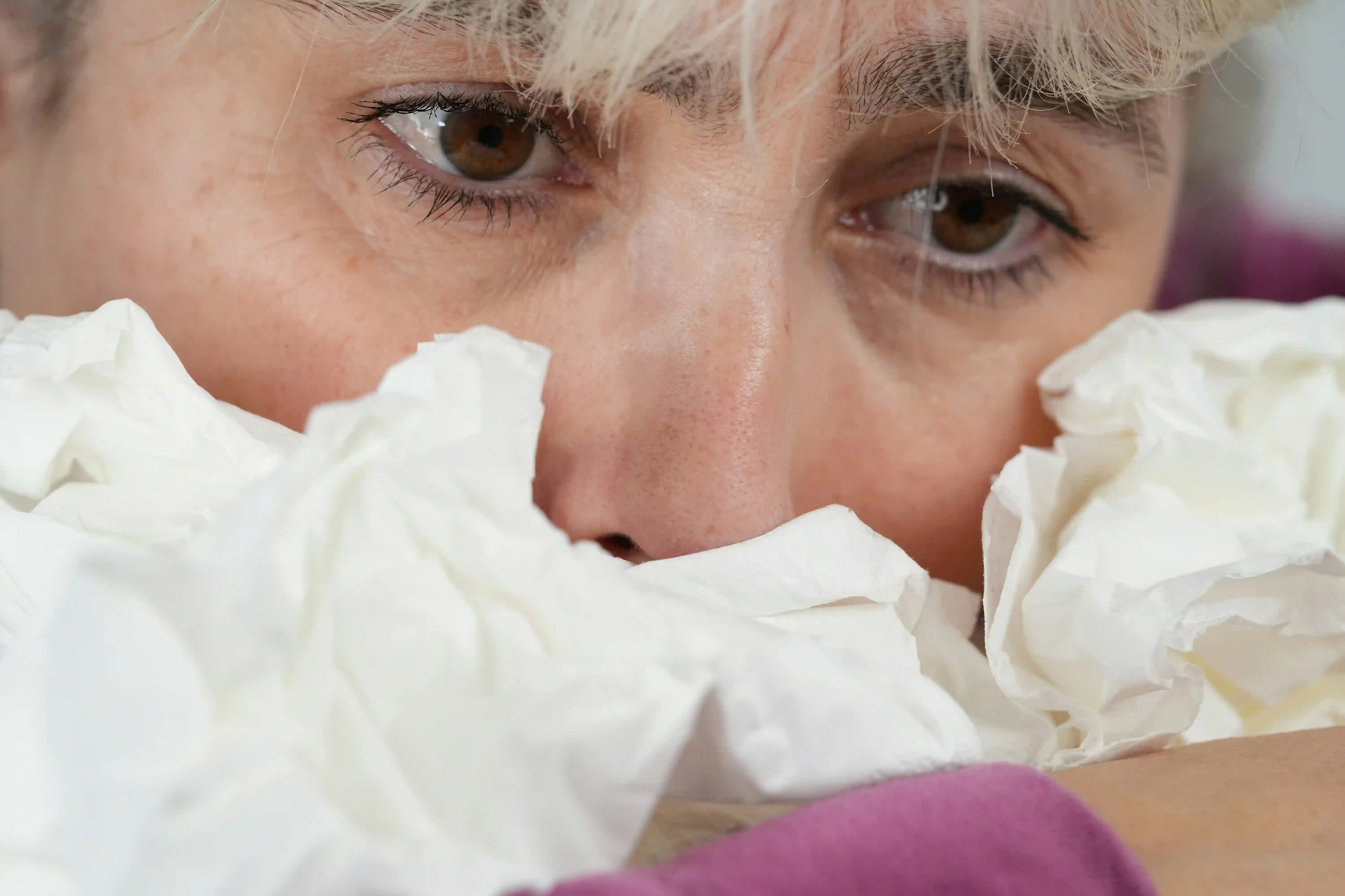 A picture showing a woman with the common cold.