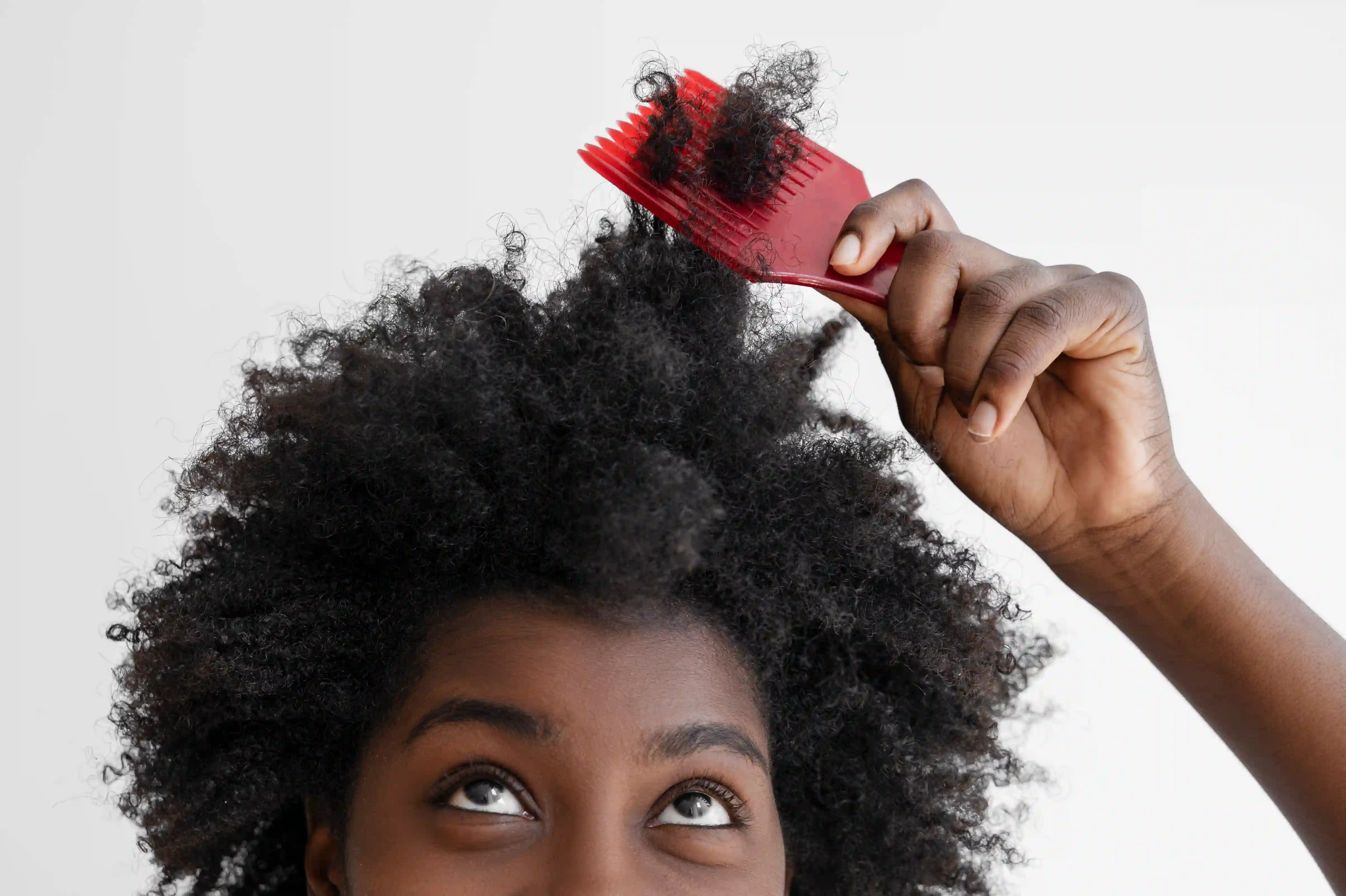 A picture showing a woman struggling to comb her fizzy hair.