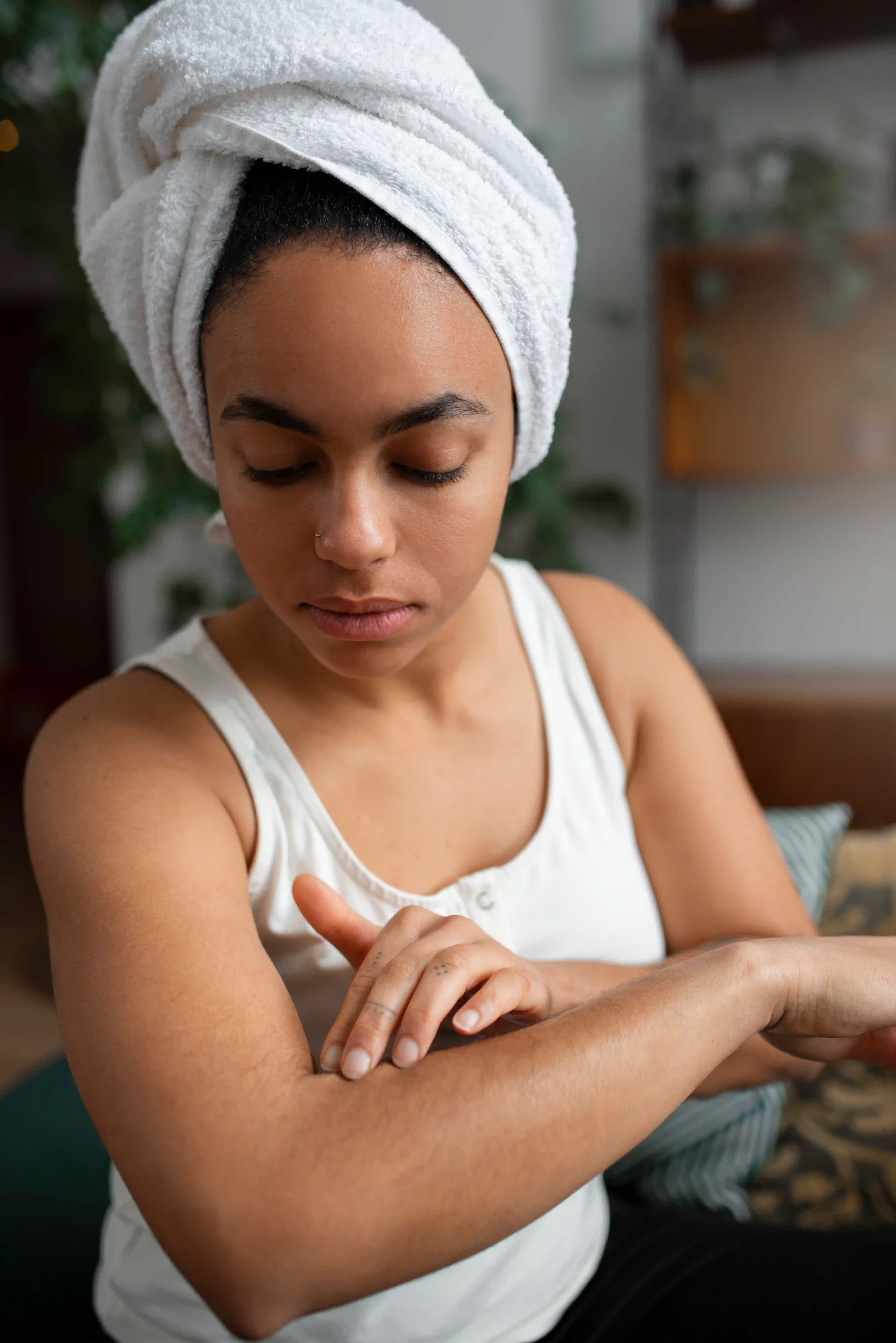 A picture showing a woman applying coconut oil to a scar on her forearm.