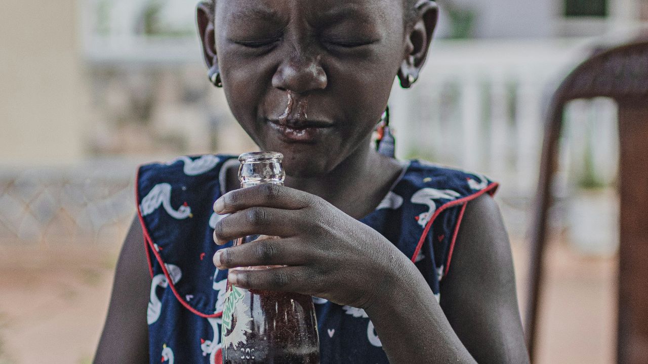 A picture showing a young woman sneeze into tissue paper with an ill-expression